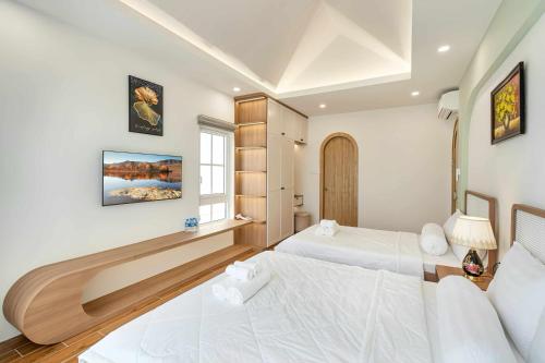 una camera da letto con due letti e una finestra di Bali Villa- BBQ Hồ bơi Karaoke - Novaworld Phan Thiết a Phan Thiet