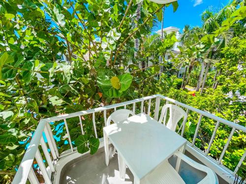 a white table and chairs on a balcony with trees at Caribbean Mojito Studios HOTEL WiFi Los Corales BEACH CLUB & SPA in Punta Cana