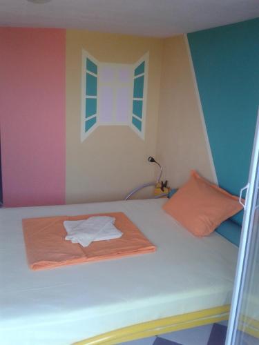 a bed in a room with a rainbow wall at The Colourful Mansion Hotel in Ahtopol