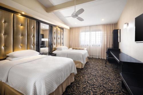 a hotel room with two beds and a television at Terra Nova, BW Premier Collection in Kingston