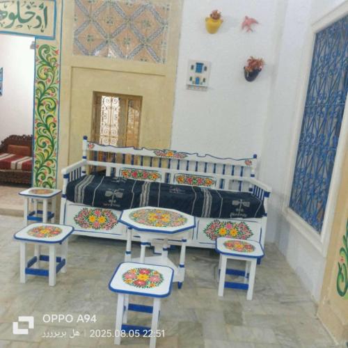 a bedroom with a bed with stools and chairs at Appartement Jasmin in Monastir