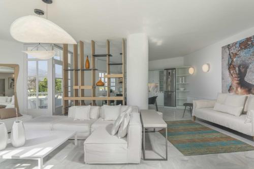 a white living room with white couches and tables at Saitis Luxury Residence - 15 min from Matala - Kommos - Kalamaki Beach in Tympáki