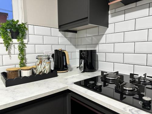 a kitchen counter top with a stove top oven at Stylish 2BR Stay- Preston City in Preston