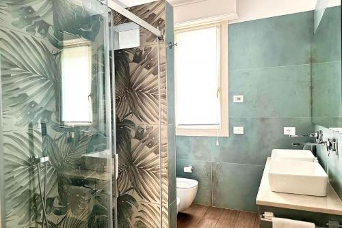 une salle de bain avec une douche en verre et un lavabo dans l'établissement Eleganza e comfort - Lago d'Iseo, à Paratico