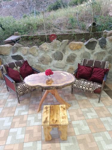 a table and two couches and a table and a bench at GeghardCamping in Goghtʼ