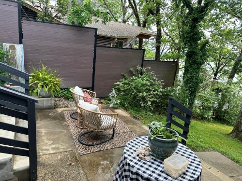 a patio with two chairs and a table and a fence at Crystal Serenity Quartz Soak The Namaste Studio On Lake Hamilton in Hot Springs