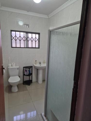 a bathroom with a toilet and a sink at Charming Cottage for Getaways in Empangeni