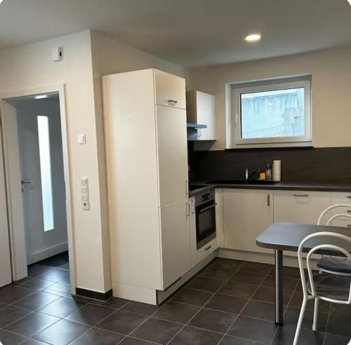 a kitchen with a table and a white refrigerator at Kleine Auszeit - Natur, Ruhe & Erholung in Birkenau