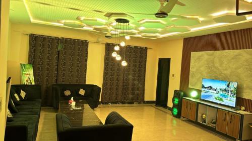 Una sala de estar con un sofá y un televisor. en Green View farms, en Faisalabad