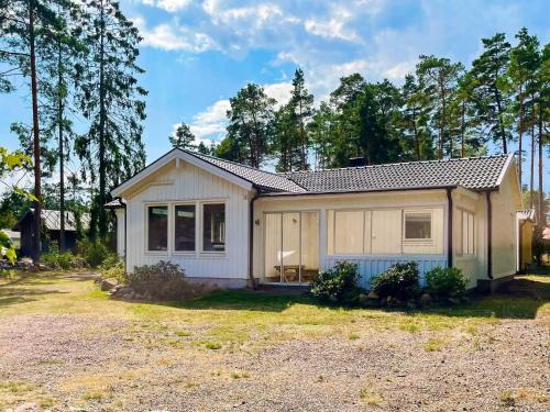 a small white house with trees in the background at 4 star holiday home in Mönsterås-By Traum in Mönsterås