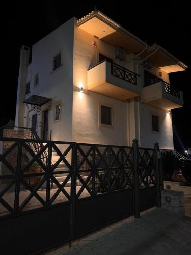 a white building with a gate and a fence at Aegina Horizon Stonehouse No I in Aegina