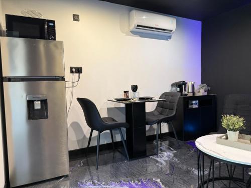 LaudunLove Room L'ecrin d'Asteria的酒吧配有桌椅和冰箱