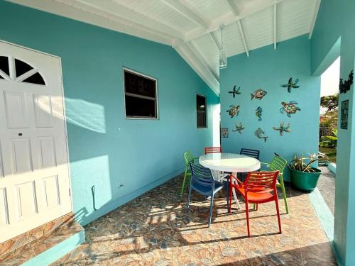 a patio with a table and chairs and a blue wall at ZenBreak Steps to the Sea 3Bd in Saint Peter