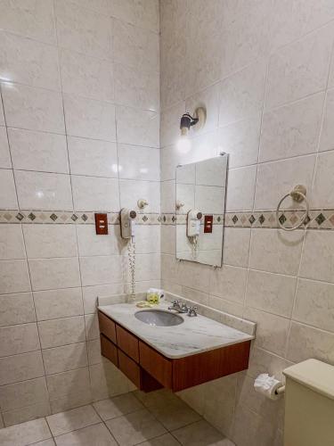 a bathroom with a sink and a mirror at Mata Atlântica Park Hotel in Matinhos