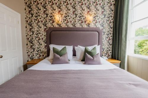 a bedroom with a large bed with purple pillows at The Royal Hotel in Bideford