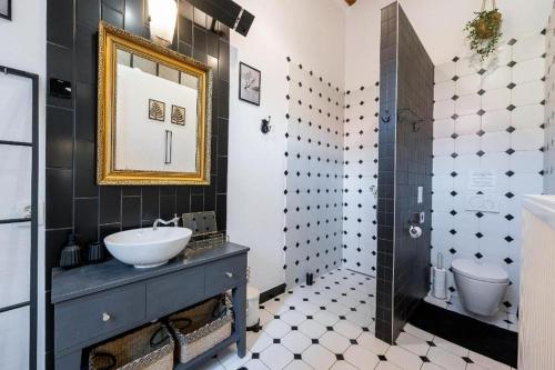 a black and white bathroom with a sink and a mirror at Amsterdam Vintage Industrial Style in Košice