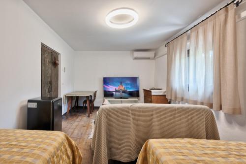 a hotel room with two beds and a flat screen tv at Country Suite 200mq in Vanzo