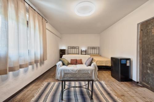 a bedroom with a bed and a couch and a chair at Country Suite 200mq in Vanzo