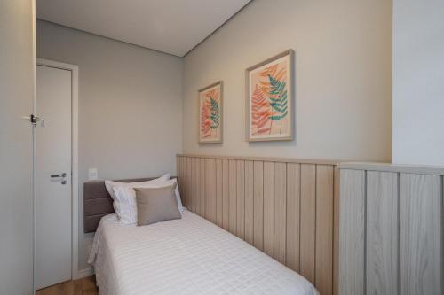 a bedroom with two beds and two pictures on the wall at Apto 2qts, Ar Condicionado, Piscina, Churrasqueira, Finamente Mobiliado e Decorado in Curitiba