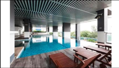 a large swimming pool with benches in a building at VUE RESIDENCE -3 ROOMs in Kuala Lumpur