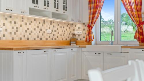a kitchen with white cabinets and a sink and a window at chalupa Kristina u Adršpachu in Teplice nad Metují