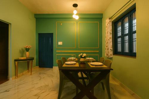a dining room with a table and a green wall at Kashivas - 2BHK near Assi Ghat in Varanasi