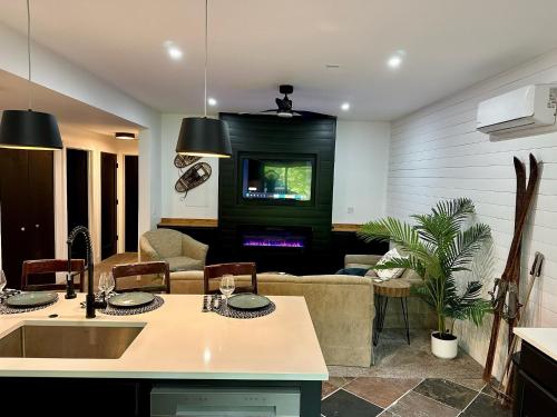 a kitchen and living room with a couch and a tv at Modern 2BR Retreat in Harbor in Harbor Springs