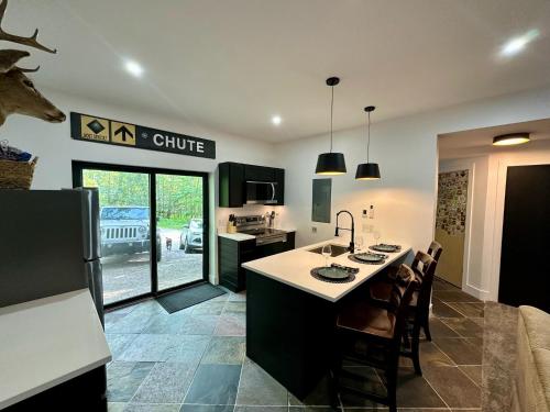 a kitchen with a kitchen island with a sink and chairs at Modern 2BR Retreat in Harbor in Harbor Springs
