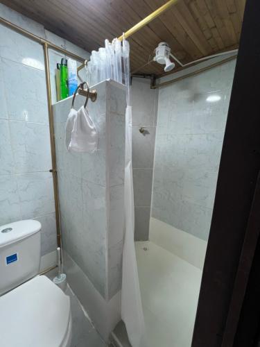 a bathroom with a shower and a white toilet at El refugio santarrosano in Santa Rosa de Cabal