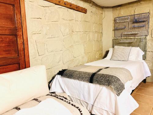 a bedroom with a bed and a brick wall at Hostal Cabaña Farellones in Santiago