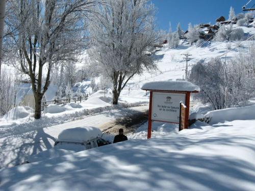 a person standing next to a sign in the snow at Hostal Cabaña Farellones in Santiago
