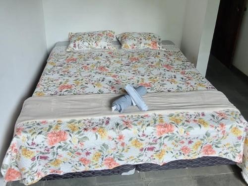 a bed with a blanket and an umbrella on it at Pousada Shema in Itatiaia