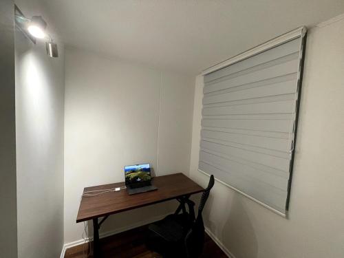 a room with a table with a window with a laptop on it at Cozy apartment with a view of the Volcanoes and Villarrica Lake in Villarrica