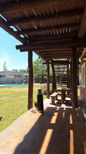 a wooden pavilion with a picnic table and a bench at Terrazas San Pedro in San Pedro