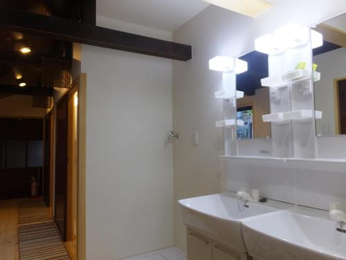 y baño con lavabo blanco y espejo. en Guesthouse Mikkaichi en Komatsu