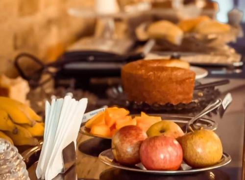 een tafel met borden fruit en gebak bij Pousada Usina Paraíso in Astolfo Dutra