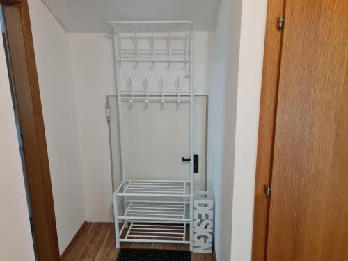 a small white refrigerator in a room with a door at FarawayHomes Pension Ramingtal in Kürnberg