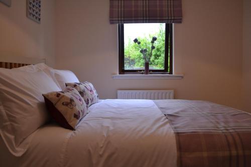 Boat Green Apartment في إدنبرة: سرير أبيض في غرفة نوم مع نافذة