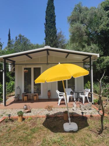 a yellow umbrella in front of a house at Apartman sa sopstvenim dvoristem , pored mora in Bigovo