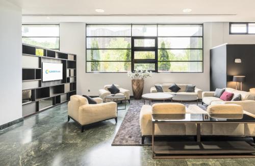 a living room with couches and a tv at Ilunion Pio XII in Madrid