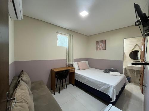 a small bedroom with a bed and a desk at Center Prime Hotel in Bom Jesus da Lapa