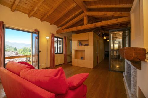 a living room with a red couch and a large window at La Casa nel Borgo Lake View - Happy Rentals in Nebbiuno