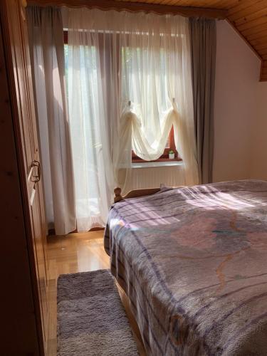 a bedroom with a bed and a window with curtains at Apartman Mira in Kremna