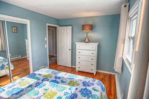 a bedroom with a bed and a dresser with a lamp at Gorgeous beach house with large pool & private beach, just 3 blocks away!! in Point Pleasant Beach