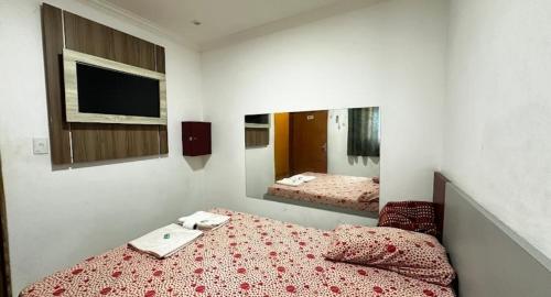 une chambre avec un lit et un miroir dans l'établissement Hotel Lalique, à São Paulo