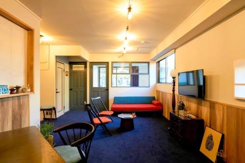 a living room with a couch and a tv at HOTEL HONjoy in Tokyo