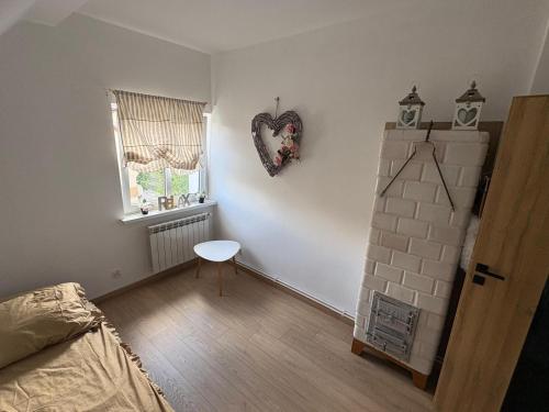 a bedroom with a heart hanging on the wall at Mazurski strych in Węgorzewo