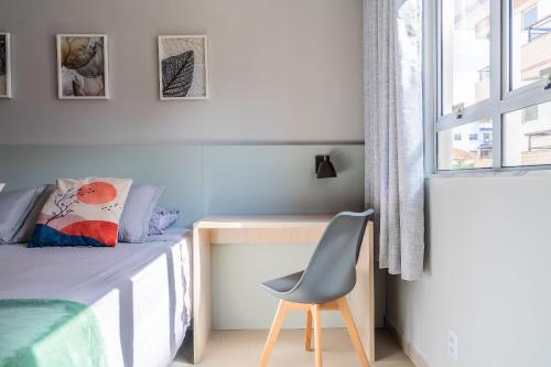 a bedroom with a bed and a chair next to a window at Elegante Ap | 3 Quartos c/Ar | 100m Praia do Forte in Škorak