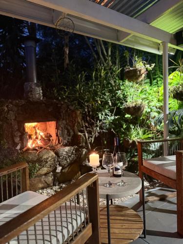 a table with wine glasses and a fireplace on a patio at Boongala - Central 3BR pet friendly family home in Maroochydore