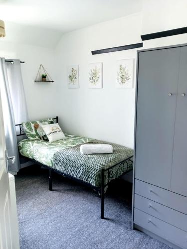 a small bedroom with a bed and a mirror at Cosy home in Walsall in Bloxwich